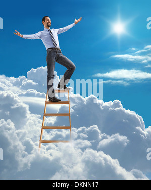 Successful businessman with open arms standing at the top of ladder high in the sky Stock Photo