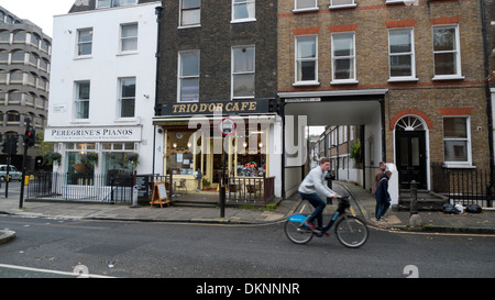 A man cycling along Guilford Street past Brownlow Mews corner Grays Inn Road  London WC1   KATHY DEWITT Stock Photo