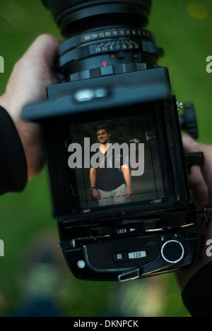 Taking a portrait through the viewfinder of a medium format camera. Stock Photo