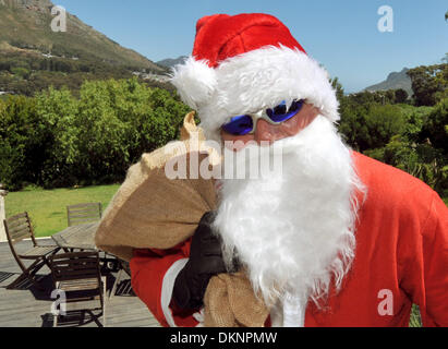 (dpa FILE) - An archive picture, dated 24 December 2011, shows a man dressed as Santa Clause walking on his way to a gift giving in Hout Bay near Cape Town, South Africa. Photo: Ralf Hirschberger Stock Photo