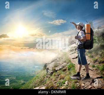 Tourist on the mountain looking at the sun Stock Photo