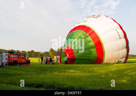 Hot air balloon being inflated before flight across countryside Stock Photo