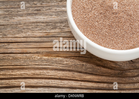 teff flour - a ceramic bowl on grained wood background Stock Photo