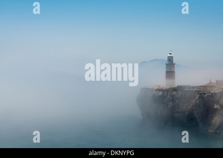 Gibraltars lighthouse at Europa Point standing in the mist with Africa in the distance. Stock Photo
