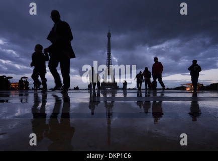 People seek shelter as it starts to rain on the Place du Trocadero across from the Eiffel Tower in Paris, France (Adrien Veczan) Stock Photo