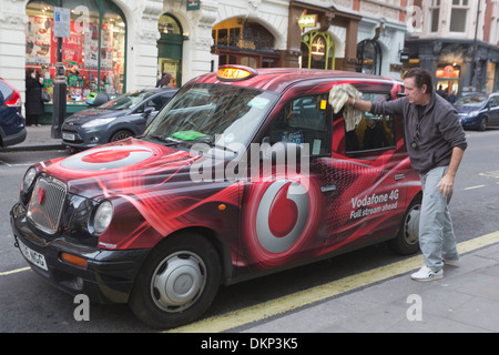 Black cab driver cleaning his car, Central London, United Kingdom Stock Photo