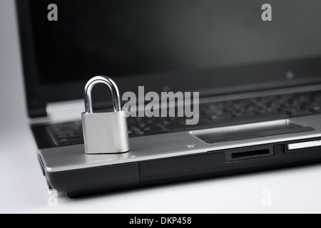 Close-up of padlock standing upright on laptop Stock Photo