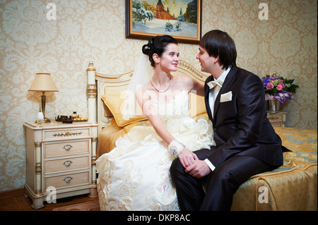 Handsome bride and groom in bedroom on wedding day Stock Photo