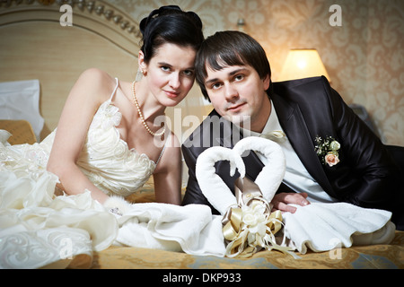 Handsome bride and groom in bedroom with towels swans on wedding day