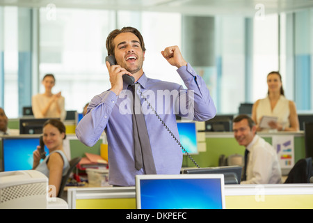 Businessman cheering in office Stock Photo