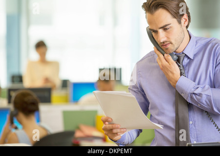 Businessman reading papers in office Stock Photo