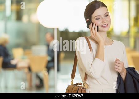 Businesswoman talking on cell phone in office Stock Photo