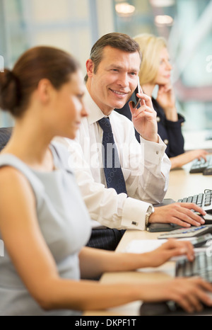 Businessman talking on cell phone in meeting Stock Photo