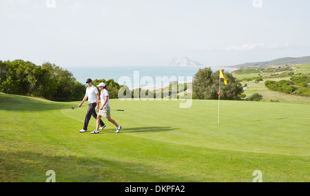 Couple walking on golf course Stock Photo