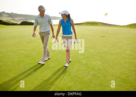 Couple walking on golf course Stock Photo