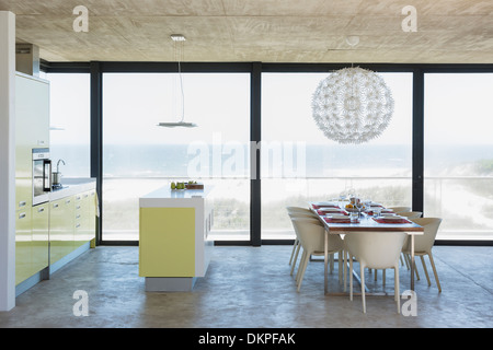 Modern dining room and kitchen overlooking ocean Stock Photo