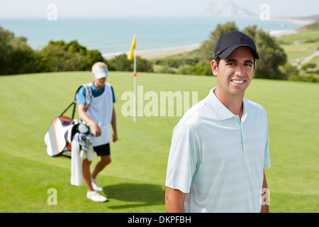 Caddy and golfer on golf course Stock Photo