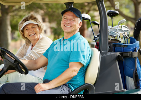 Senior couple smiling in golf cart Stock Photo