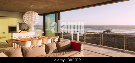 Modern living room and dining room overlooking ocean Stock Photo