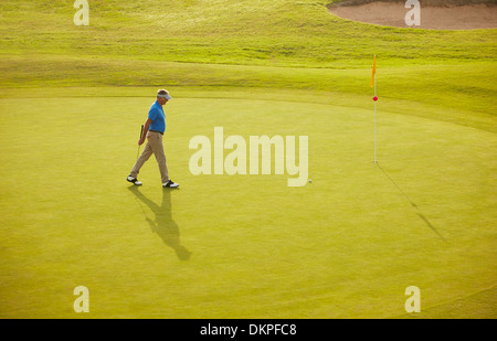 Man walking on golf course Stock Photo