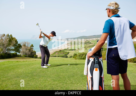 Men playing golf on course Stock Photo