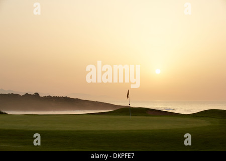 Sunset over ocean and golf course Stock Photo