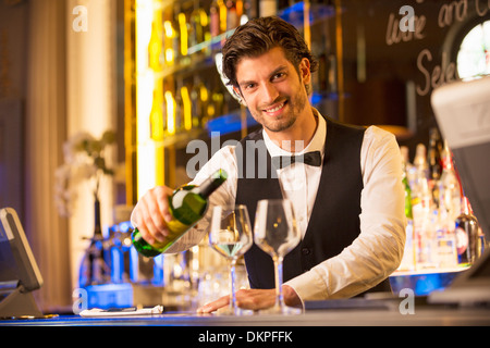 Portrait of well dressed bartender pouring wine in luxury bar Stock Photo