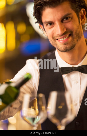 Close up portrait of well dressed bartender pouring wine Stock Photo