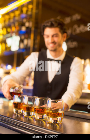 Well dressed bartender pouring bourbon in luxury bar Stock Photo