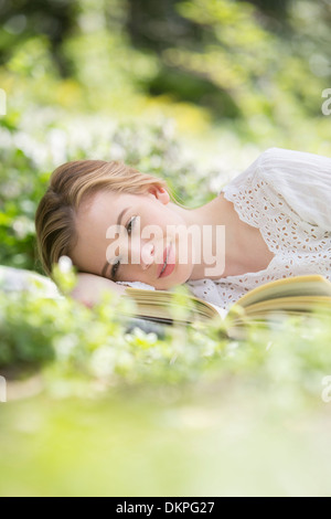 Woman relaxing in grass with book Stock Photo