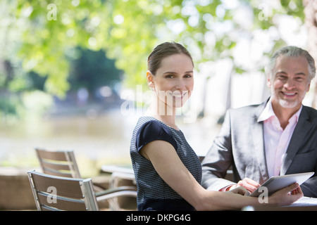 Business people smiling at sidewalk cafe Stock Photo