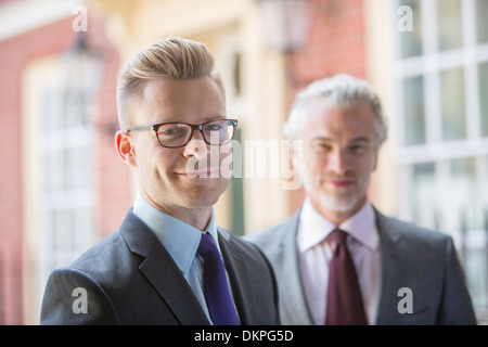 Businessmen smiling on city street Stock Photo