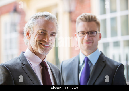 Businessmen smiling on city street Stock Photo