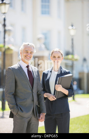 Business people smiling on city street Stock Photo