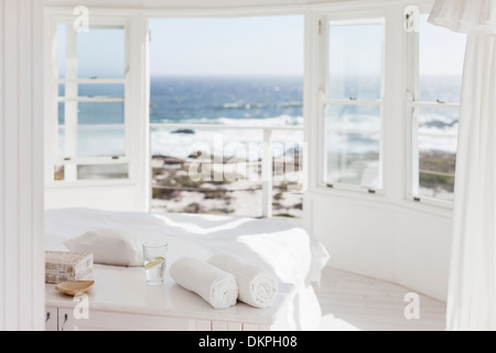 White bedroom overlooking ocean Stock Photo