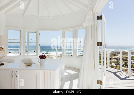 White bedroom overlooking ocean Stock Photo