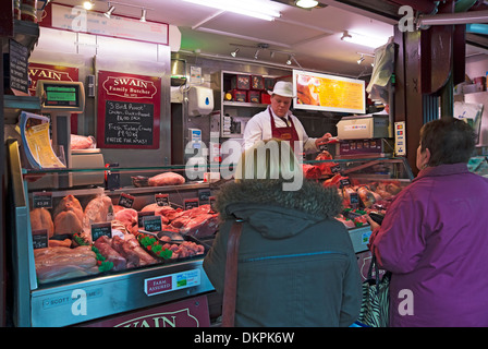 People customers at Market trader stall local butcher butchers selling buying fresh meat York North Yorkshire England UK GB Great Britain Stock Photo