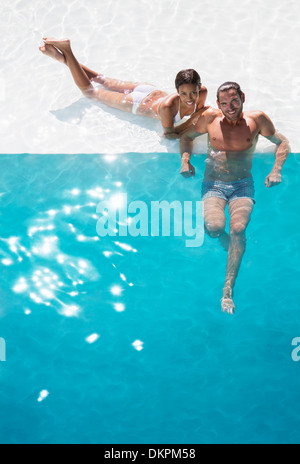 Portrait of smiling couple relaxing in swimming pool Stock Photo