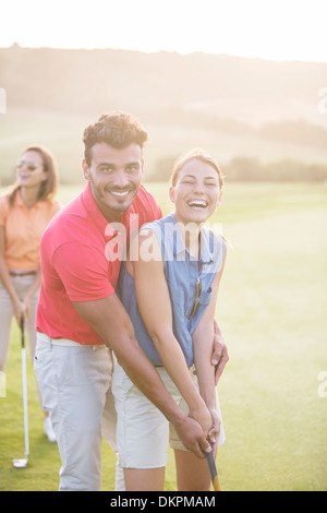 Couple playing golf on course Stock Photo