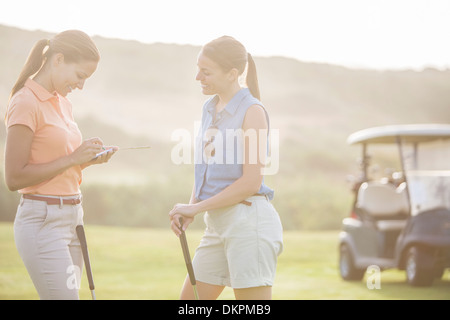 Women playing golf on course Stock Photo