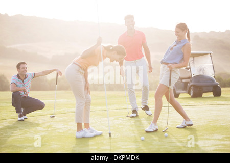 Friends laughing on golf course Stock Photo