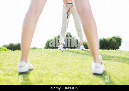 Women putting on golf course Stock Photo