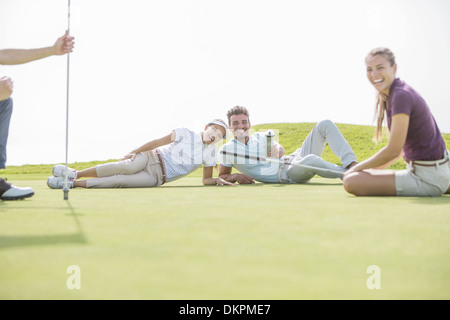 Friends laying on golf course Stock Photo
