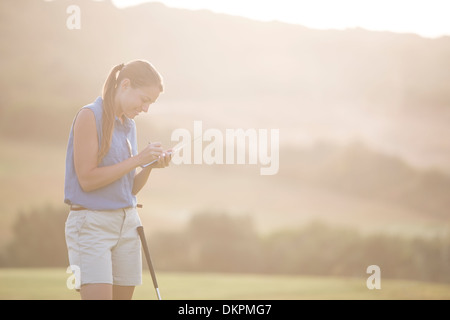 Woman with scorecard on golf course Stock Photo