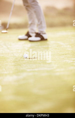Man putting on golf course Stock Photo