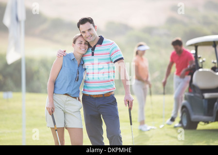 Couple hugging on golf course Stock Photo