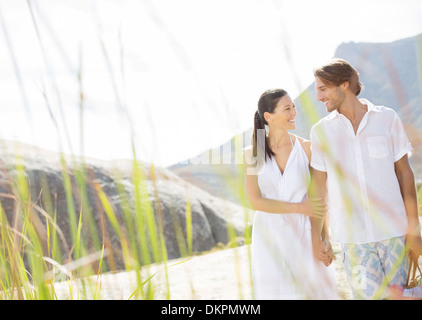 Couple walking together by beach Stock Photo