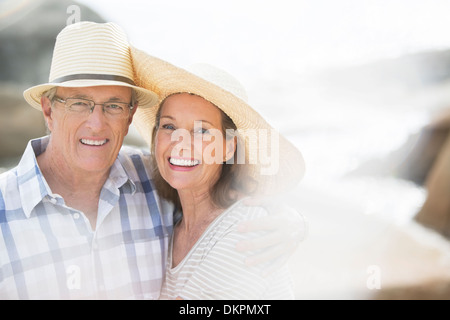 Older couple smiling on beach Stock Photo