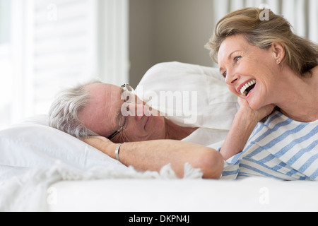Older couple relaxing on bed Stock Photo