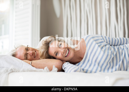 Older couple relaxing together on bed Stock Photo
